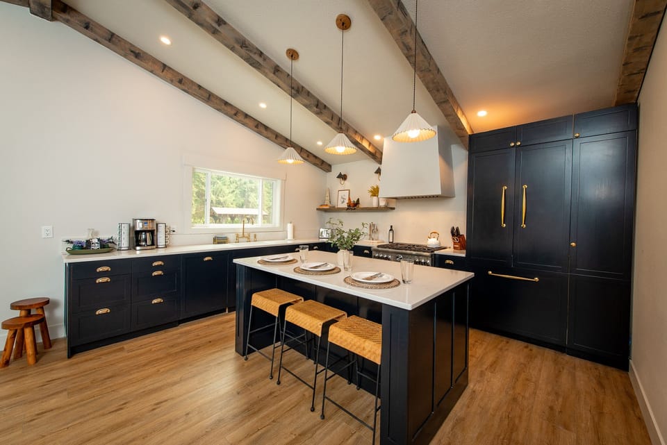 Custom kitchen with large island, gas stove top, custom paneled fridge and dishwasher