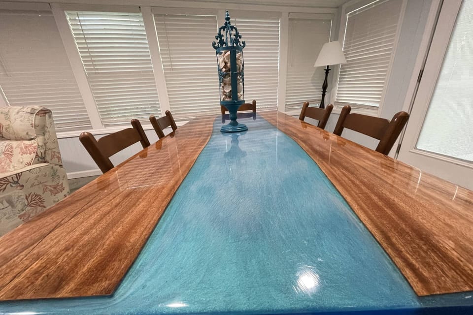 The Star of the Sunroom is this Dining Table (Seats 6), with a Swath of Tidepool Blue Resin Flowing down the Center.
