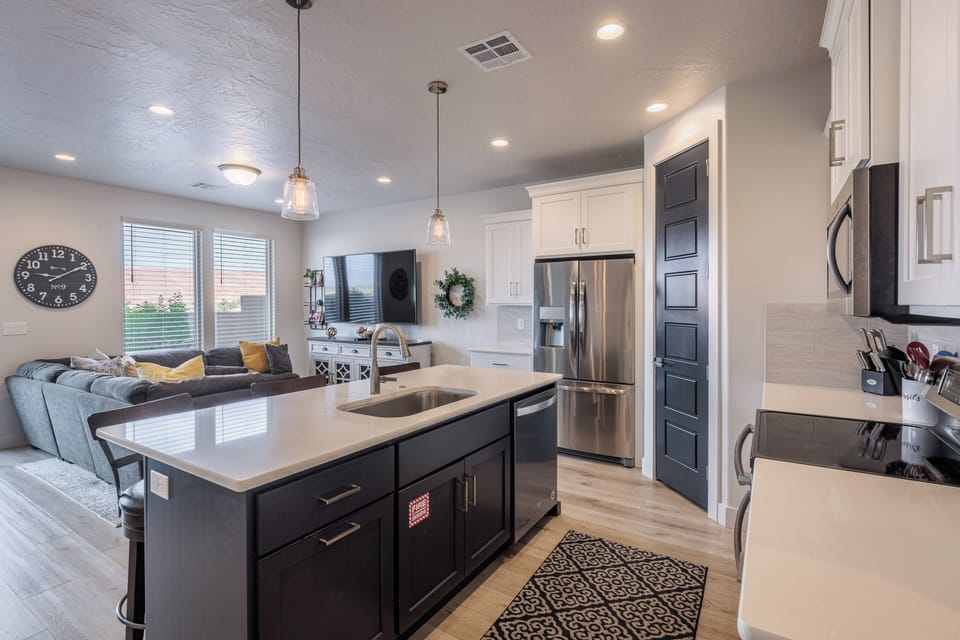 Kitchen Island View - Side view of kitchen showing off the beautiful counter tops and stainless-steel appliances.
