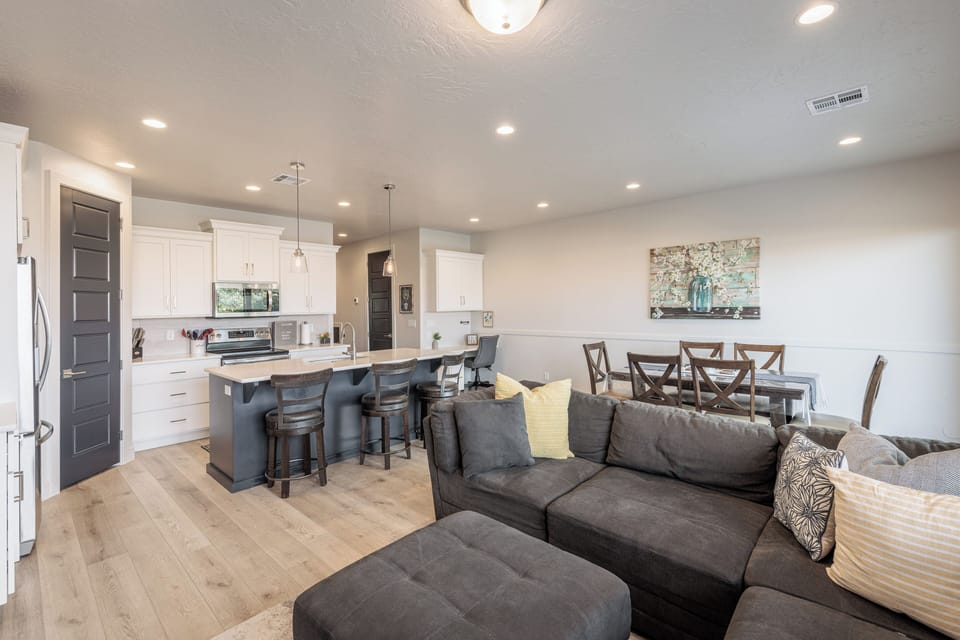 Living Area Kitchen Side View - The living room is designed as an open floor plan and is a great gathering place for meals, games, or watching TV during your stay.