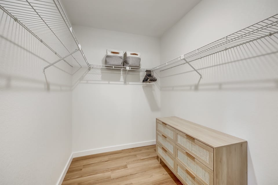 Walk in Closet in Primary Bedroom- Plenty of closet and drawer space for the clothes you bring with you and the clothes you purchase at  The Domain outdoor mall (5 Min). Also comes with a hamper, ironing board, and iron.