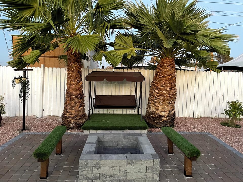 Tranquil Backyard Haven: Swing, Firepit, Cozy Bench, Lush Greenery
