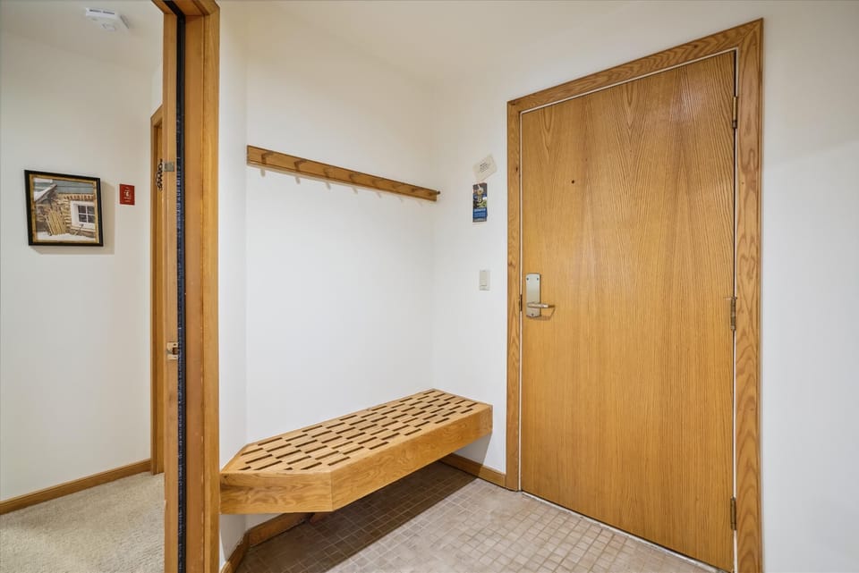 The welcoming mudroom entry includes bench seating and wall hooks for coats, boots, and ski gear.