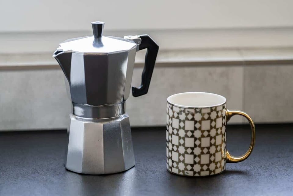 A close-up of a coffee maker and a mug on a dark countertop, adding a cozy touch.

