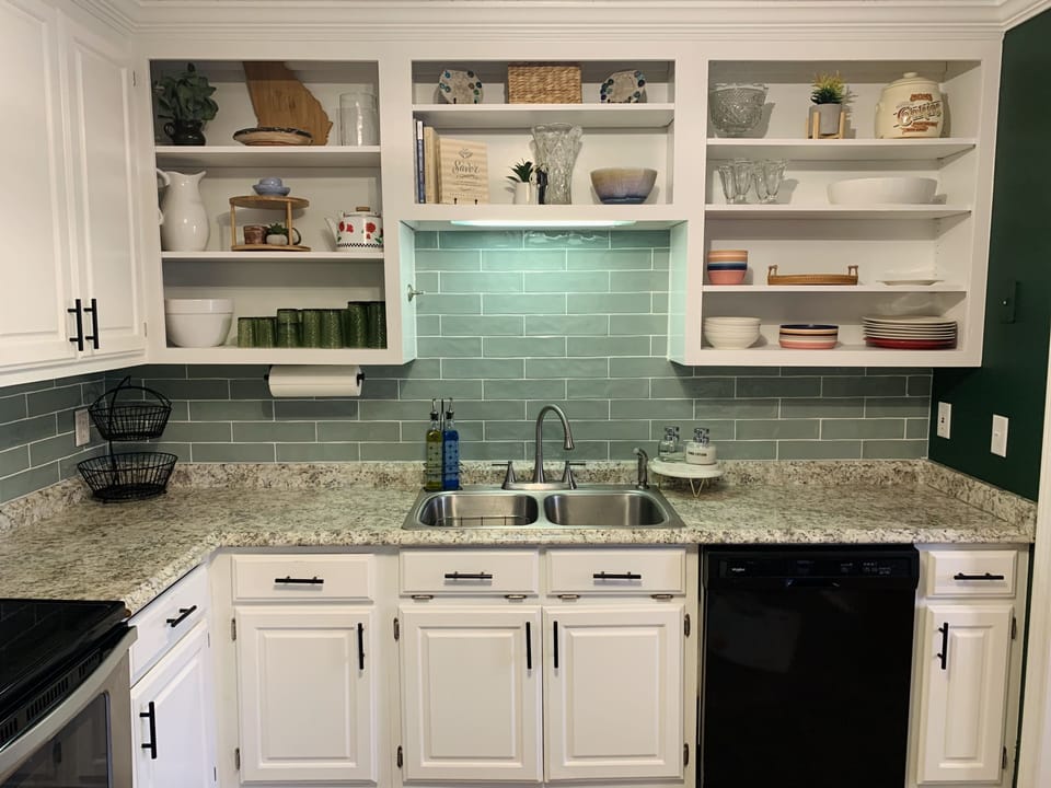 Brand new tiled backsplash and hardware elevate this cozy kitchen!