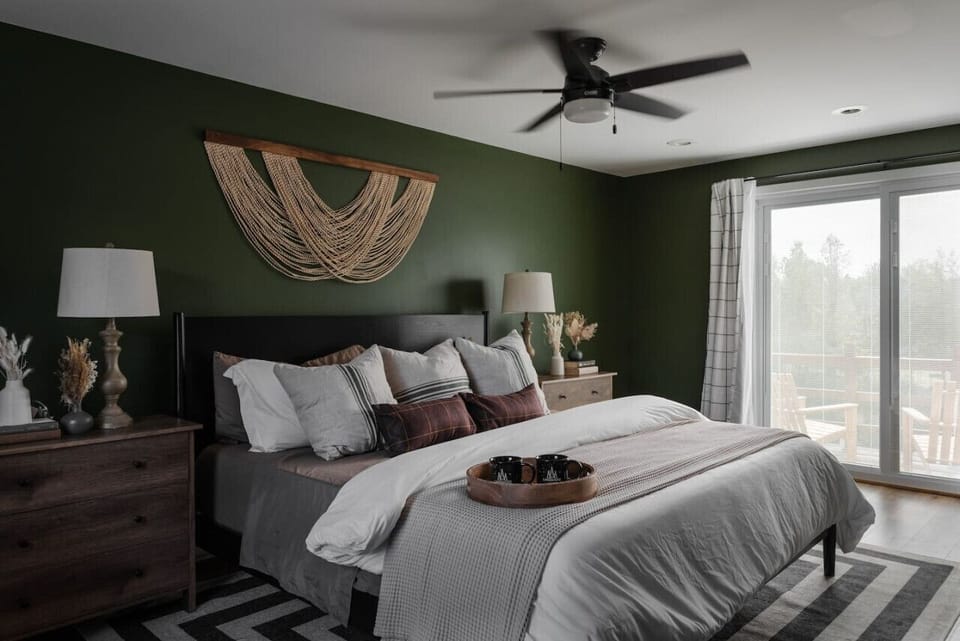 A restful bedroom featuring serene green tones and a refreshing ceiling fan for ultimate comfort.
