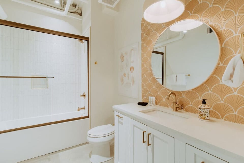 Refresh and recharge in our spa-inspired bathroom, featuring elegant gold fixtures and cheerful coastal touches.