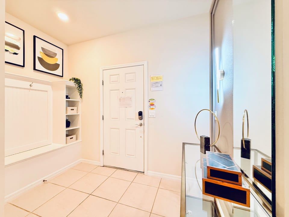 Entry mudroom with storage bench, coat hooks, and keyless door lock.