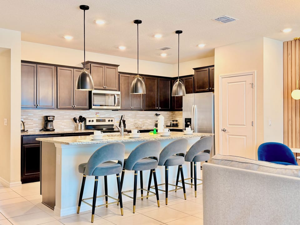 Gourmet kitchen with dark shaker cabinets and granite island bar.