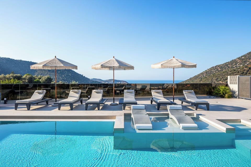 Two private, 56 sq.m. swimming pools, adorned with a graceful waterfall and two in-pool chaise longues