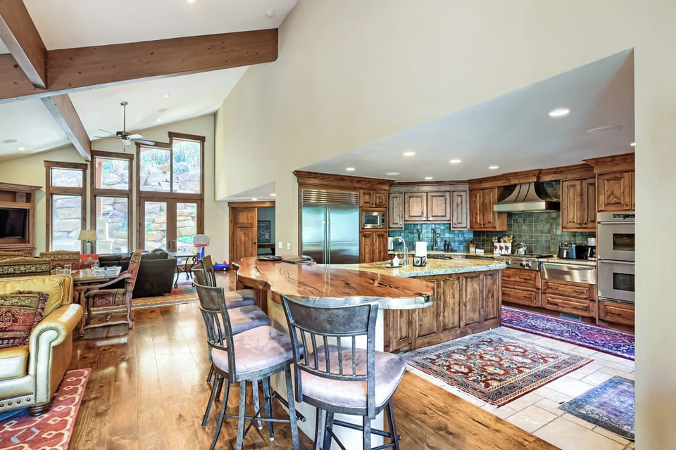 Gather around the handcrafted wood island in your gourmet kitchen, where rustic warmth meets modern appliances. Vaulted ceilings and natural light create an open, airy space perfect for cooking and conversation.