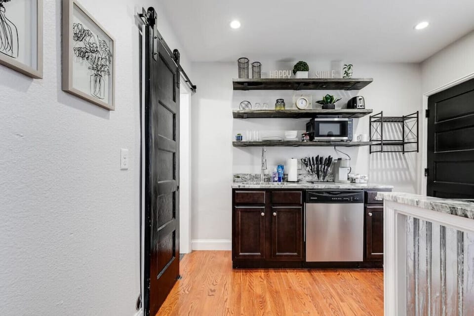 Well-appointed kitchen with open shelving, microwave, toaster, Keurig coffee maker, electric stove, dishwasher, fridge, freezer and more!