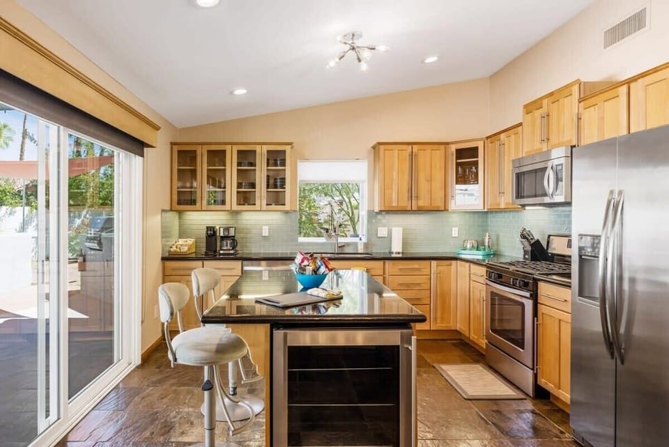The spacious kitchen is outfitted with a large island, stainless steel appliances and granite countertops, making cooking a breeze