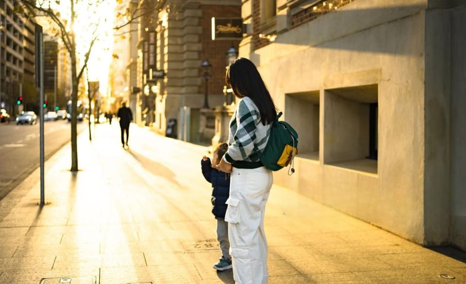 Stroll through golden-lit streets, where warm sunlight filters through the trees, casting a dreamy glow on the city. A peaceful walk filled with connection and quiet charm.