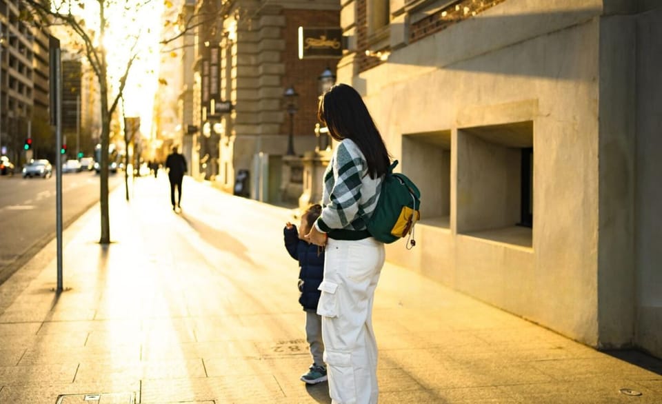 Stroll through golden-lit streets, where warm sunlight filters through the trees, casting a dreamy glow on the city. A peaceful walk filled with connection and quiet charm.