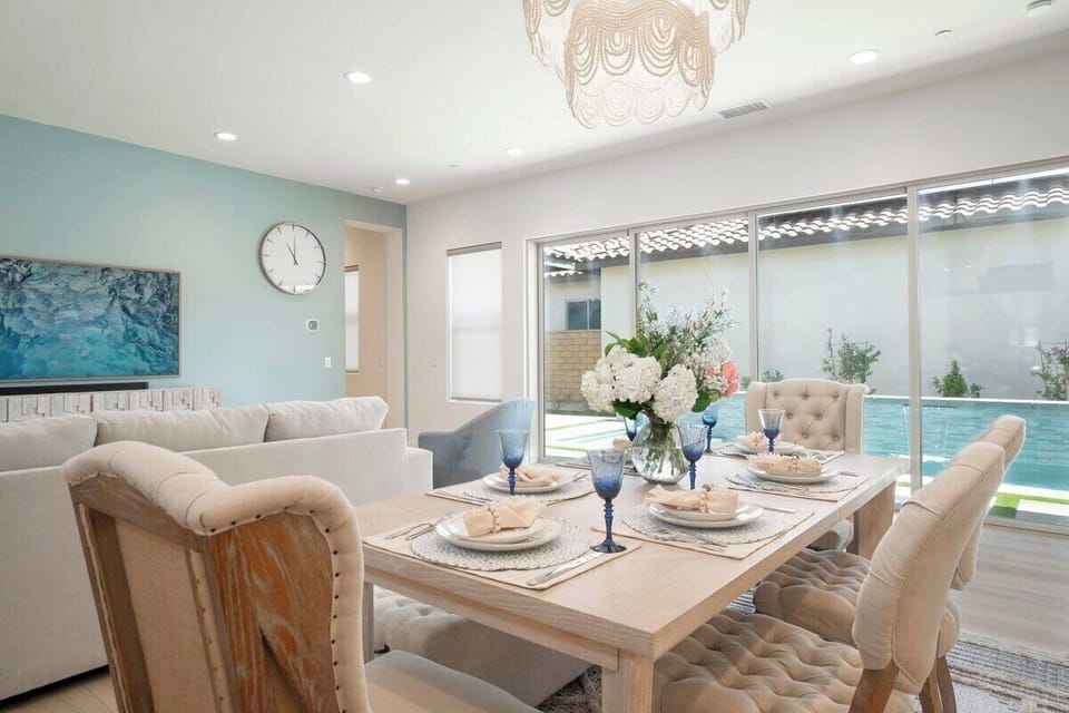 Tufted chairs and sleek table—dining room flows naturally into living and kitchen areas.