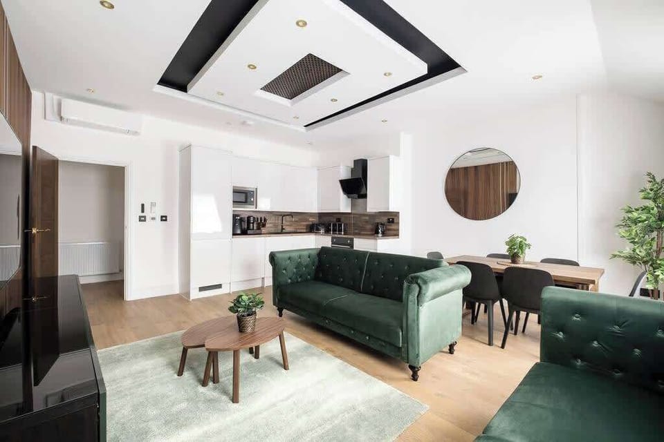 Living Room | Relax in sheer luxury within a beautifully designed living room, featuring wooden panels, marble walls, and ambient LED lighting. This super spacious sanctuary is adorned with a 70-inch smart TV and equipped with air conditioning.