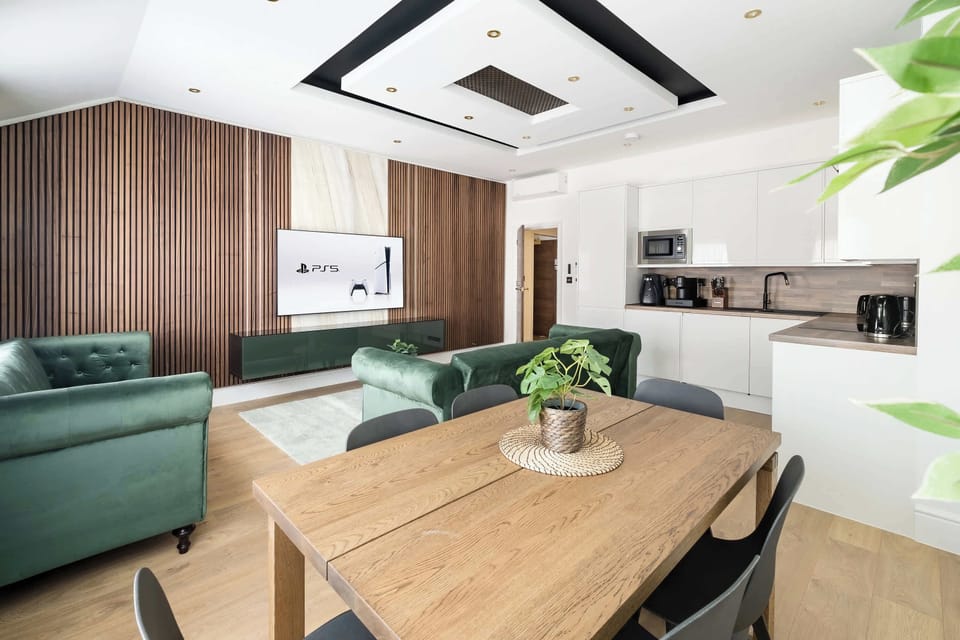 Living Room | Relax in sheer luxury within a beautifully designed living room, featuring wooden panels, marble walls, and ambient LED lighting. This super spacious sanctuary is adorned with a 70-inch smart TV and equipped with air conditioning.