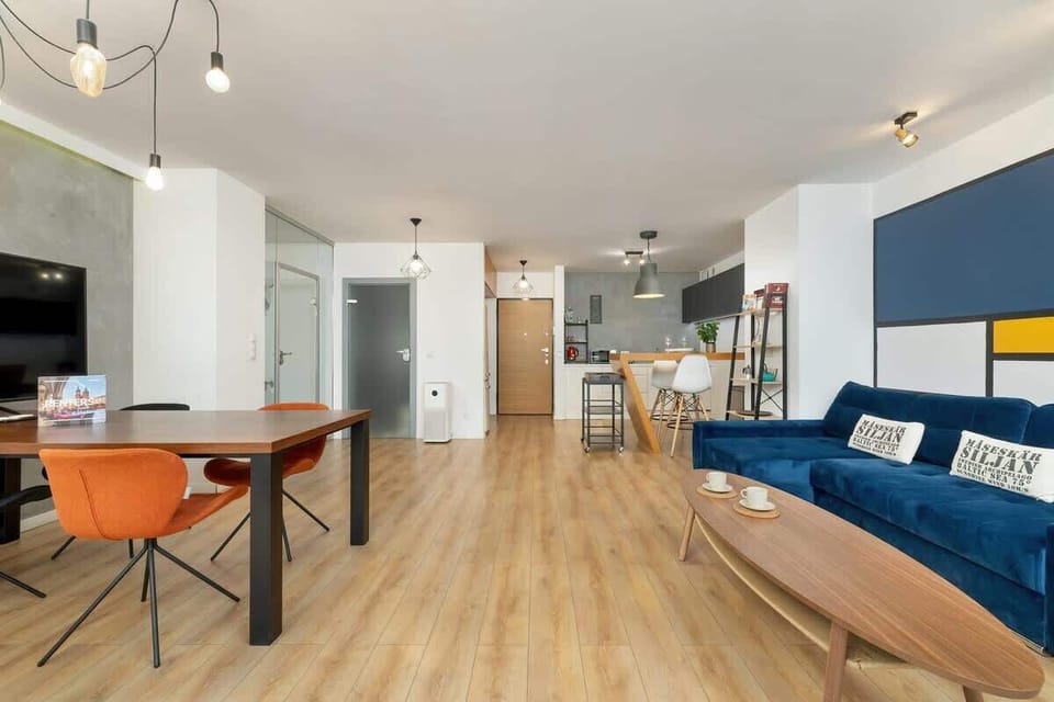 A detailed look at the dining area, with a modern table and chairs, positioned next to large glass doors.

