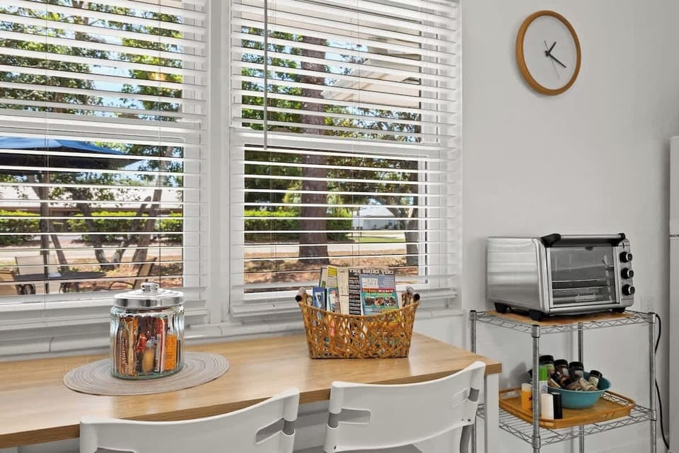 Dinette table for two, welcome brochures, treats for guests, air fryer, and spices. 