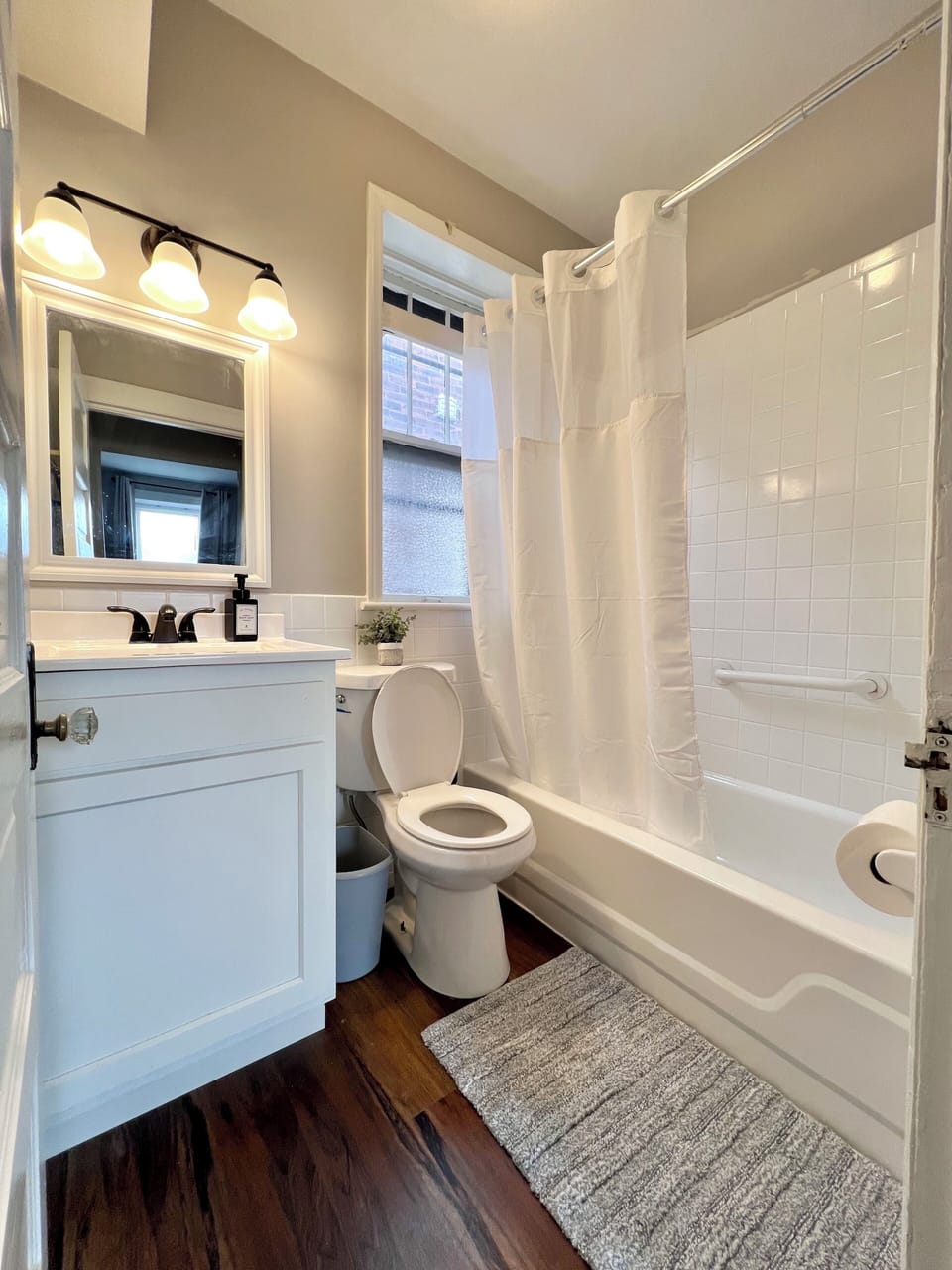 Full bathroom with shower/tub combo, towels, and hand soap.