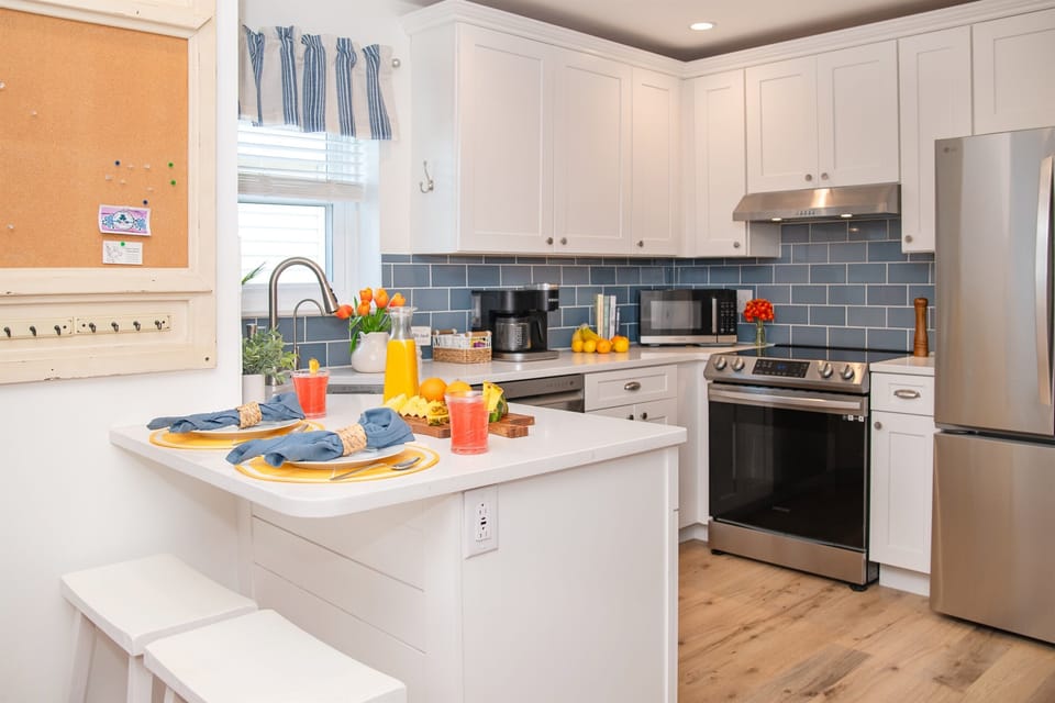 Fully stocked coastal kitchen with stainless appliances, filtered cold water dispenser and filtered ice maker in freezer.