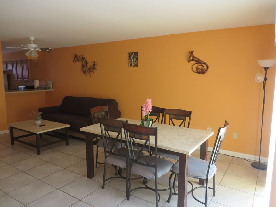 Main living area. 3 sofa bed couch, large dining table, ceiling fan, smart TV.