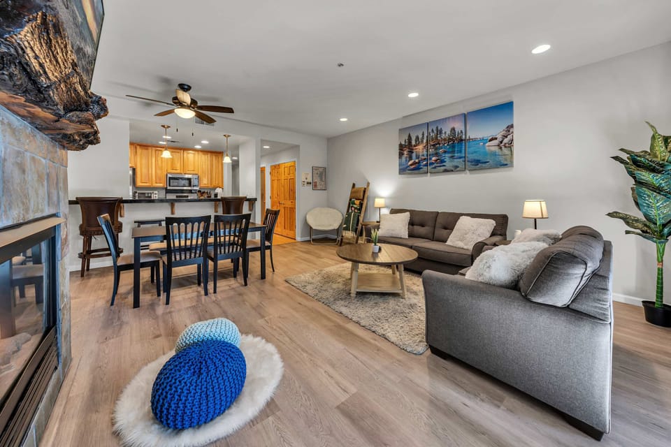 Living room: Gas fireplace, 55” Smart TV, pull-out full sofa, hardwood floors, forest views