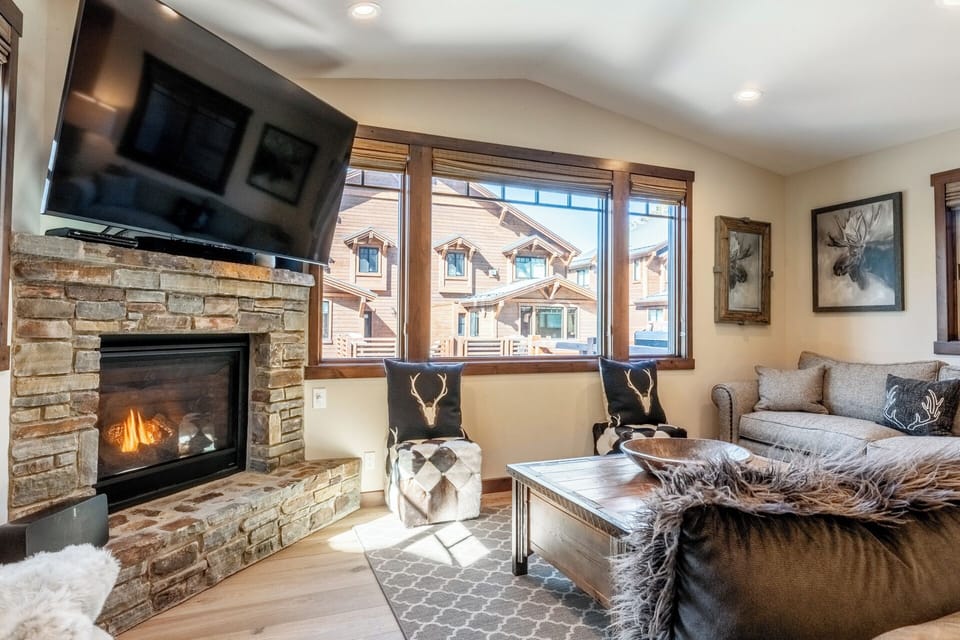 The welcoming heart of Bear’s Den at Mountainside #6—a warm gathering space with fireplace, comfortable seating, and room for everyone to relax after a day on the mountain.