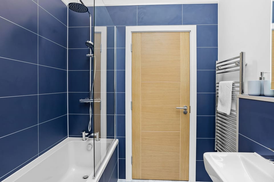Family bathroom with shower over bath, handheld shower head, heated towel rail and sink - 7 The Vista, Willingcott