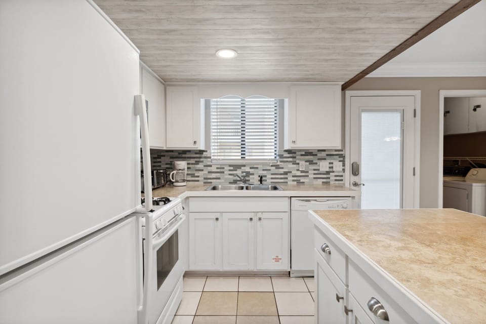 Modern kitchen with white cabinetry and a tiled backsplash for a clean, functional space.