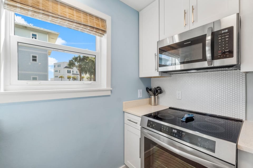 modern kitchen corner with stainless steel appliances and natural light from the window