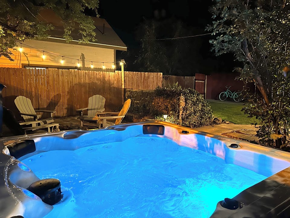Relax in the private hot tub under bistro lighting