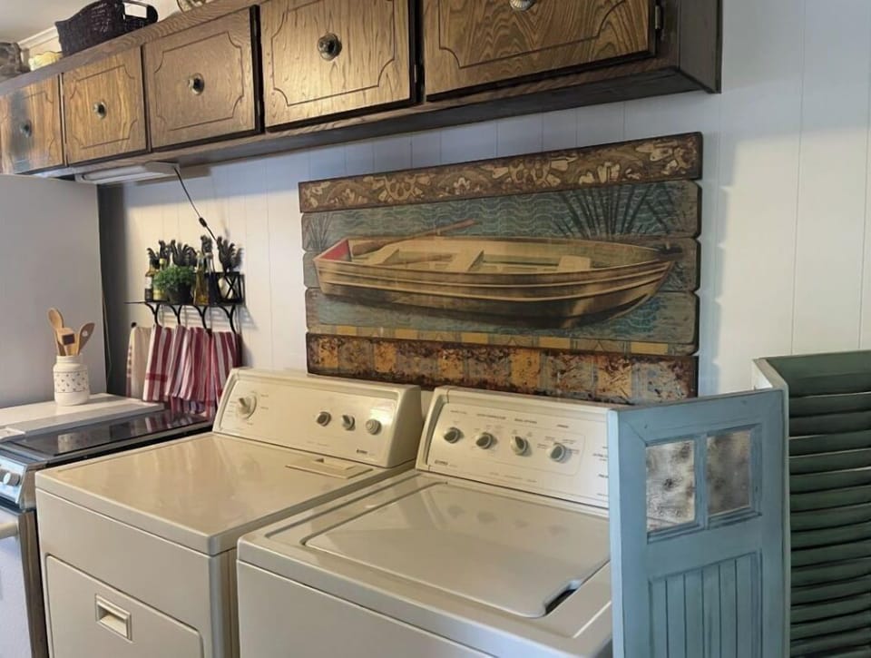 Front entry washer and dryer in kitchen next to stove and refrigerator 