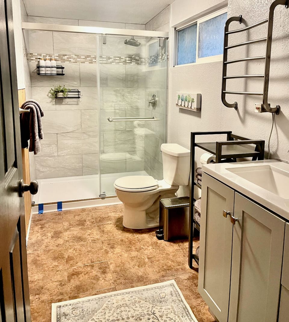 Large, remodeled bathroom with walk in shower and heated towel bar.