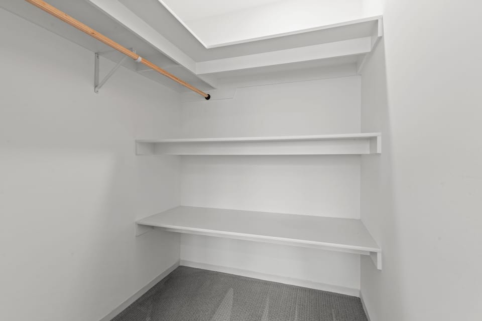 Spacious walk-in closet with shelving and hanging space, perfect for longer stays and keeping your space organized and clutter-free.
