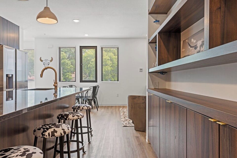 Modern kitchen with a large island and bar seating, offering a perfect spot for breakfast, coffee, or casual meals. Bright, open layout ideal for a comfortable stay in walkable Downtown Shawnee.