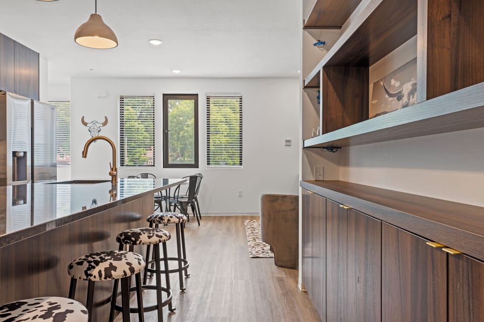 Modern kitchen with a large island and bar seating, offering a perfect spot for breakfast, coffee, or casual meals. Bright, open layout ideal for a comfortable stay in walkable Downtown Shawnee.