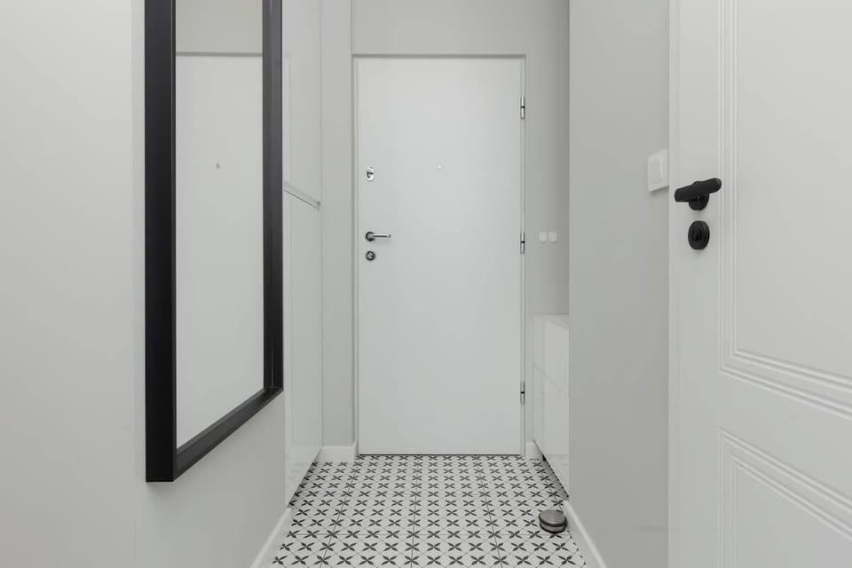 The apartment's entrance hallway with minimalist design and bold patterns on the floor tiles.

