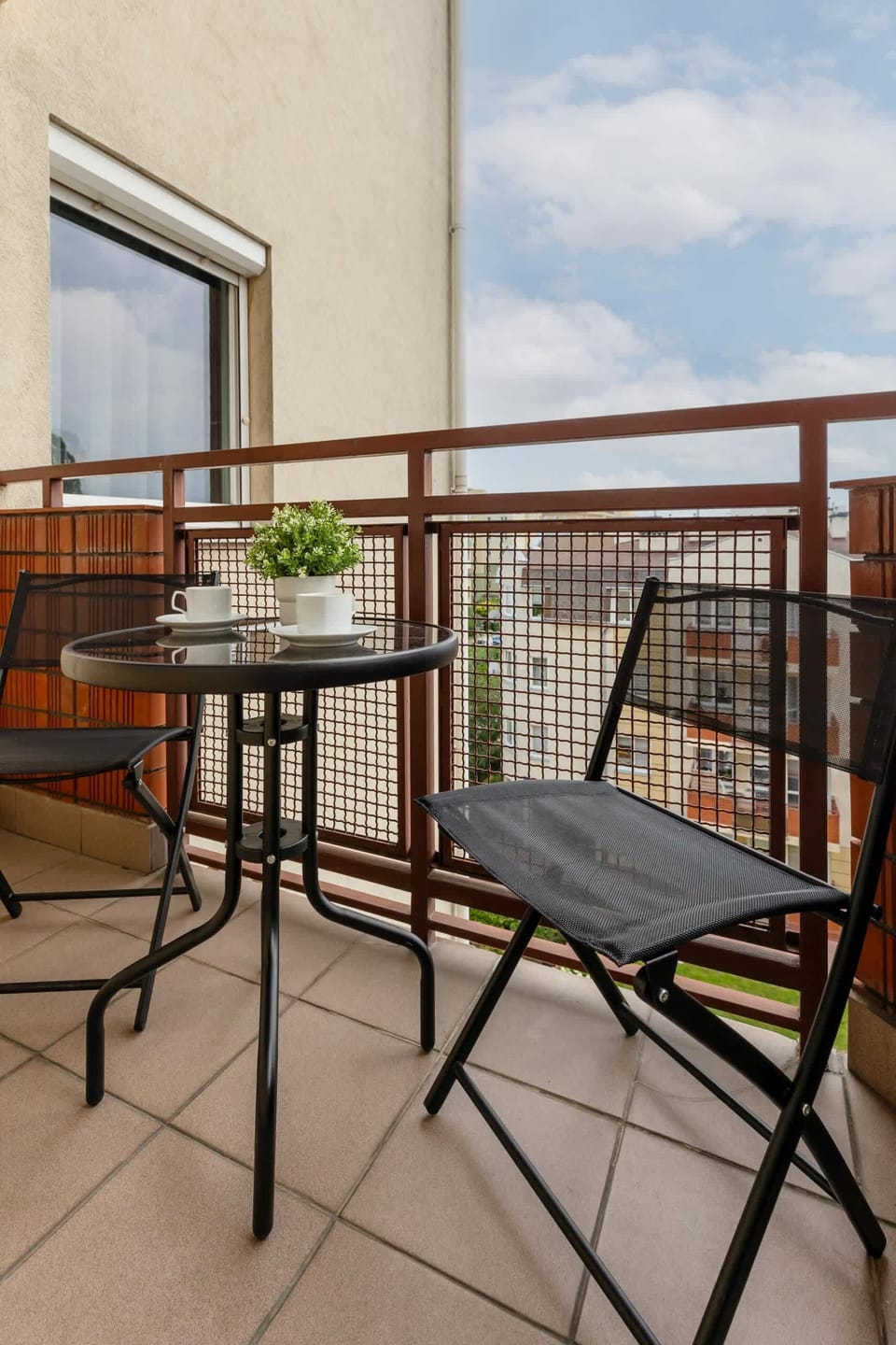 A cozy balcony with a table and chairs, offering a relaxing spot to enjoy the view or a cup of coffee.
