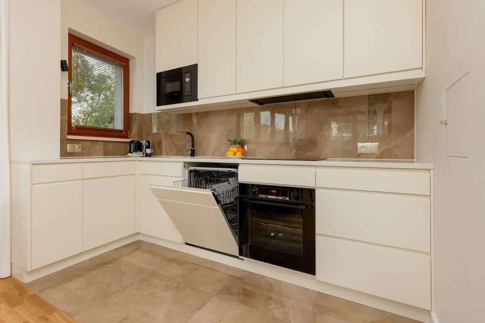 A well-equipped kitchen with a clean, neutral design and high-end appliances for a functional cooking experience.

