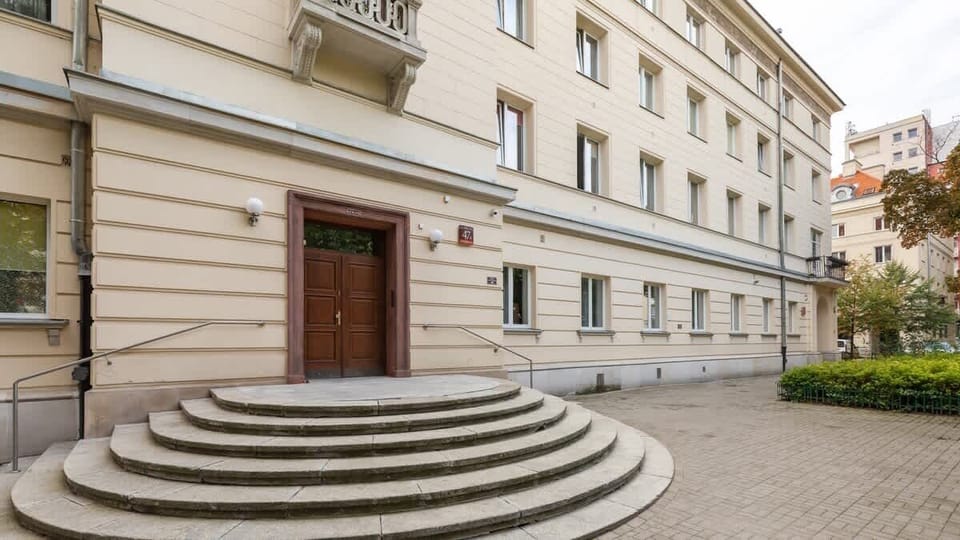 An exterior view of the building entrance, featuring beautiful architecture with wide steps and a well-maintained facade.