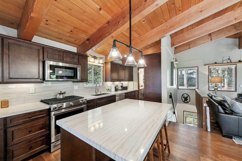 Bright, welcoming kitchen with wood beams, modern appliances, and a cozy island—perfect for cooking, gathering, and sharing meals.