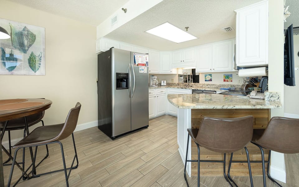 Granite counters wrap this kitchen where you can sip morning coffee at the breakfast bar before the day begins