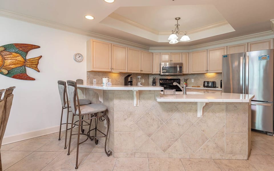Gather around the sleek breakfast bar, featuring stylish seating and a vibrant fish artwork that adds charm to your stay