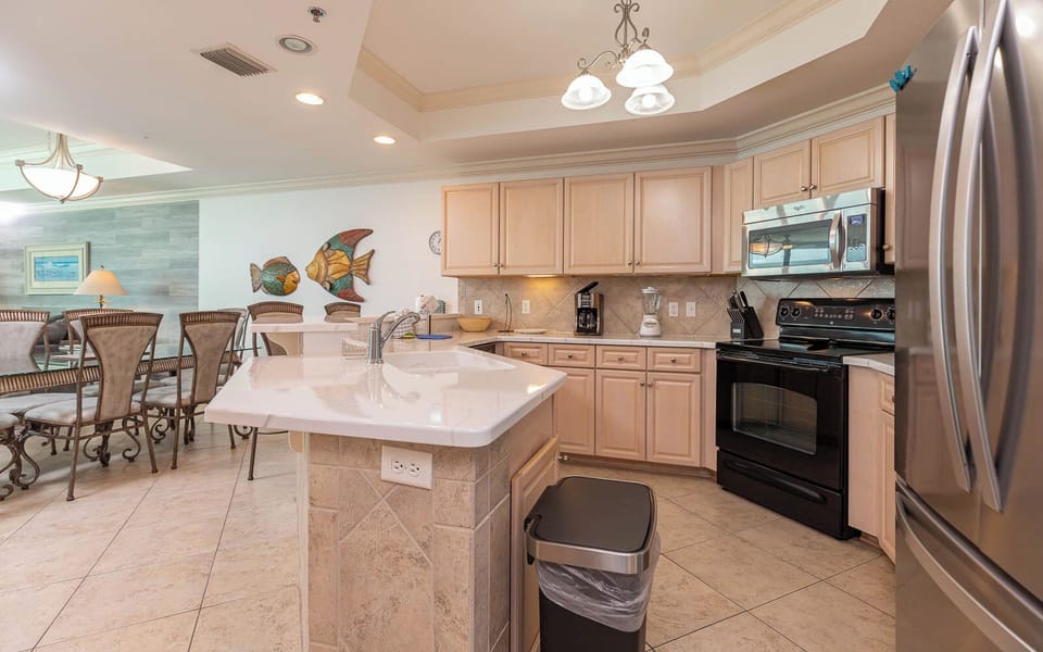 Prepare meals in this inviting kitchen, featuring ample counter space and charming fish-themed decor for a delightful