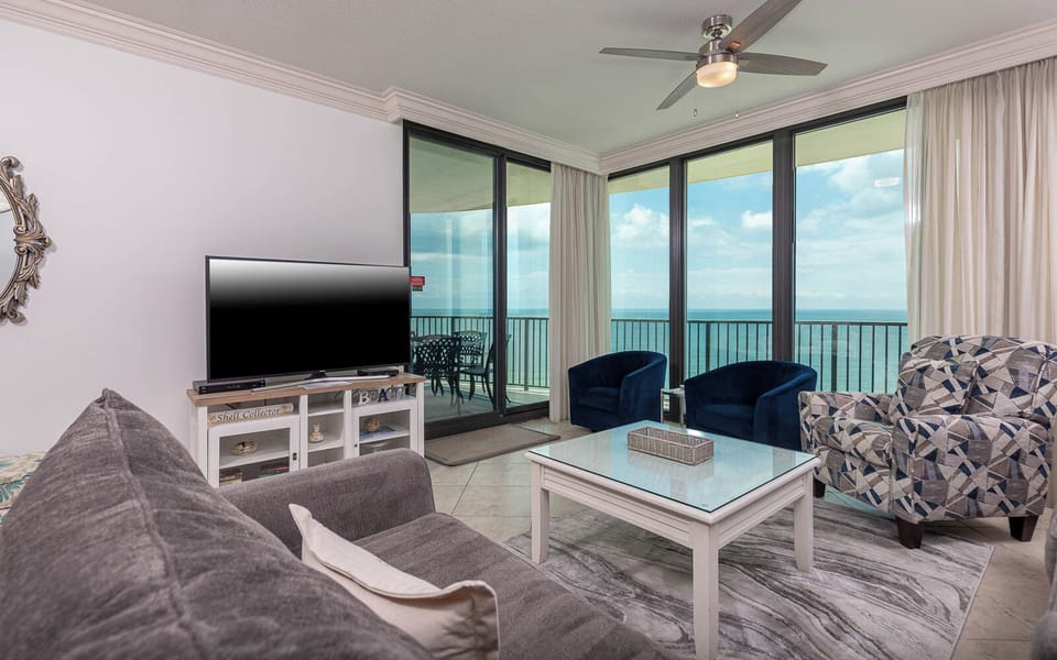 Inviting living area with sofa with full sleeper, twin sleeping chair, and a large TV, perfect for relaxing after a beach day