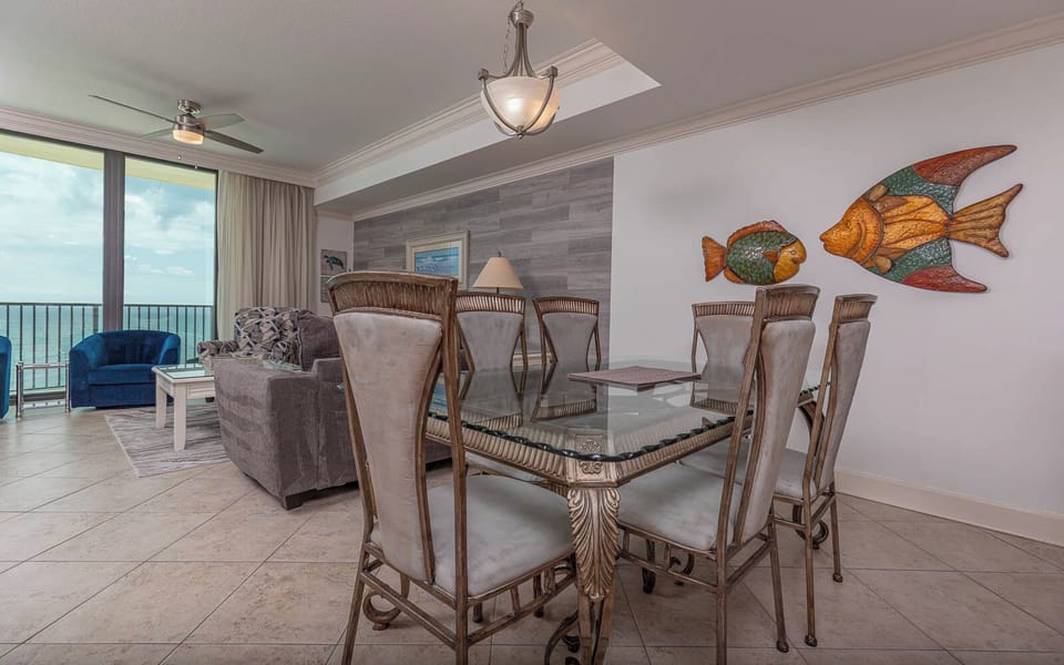 Dine comfortably at the elegant glass table, surrounded by stylish chairs and vibrant fish decor