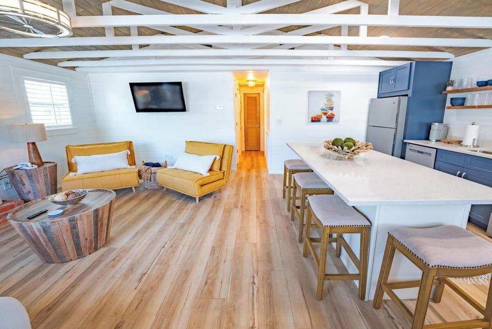 open-concept living area with modern kitchen and seating for four at the island