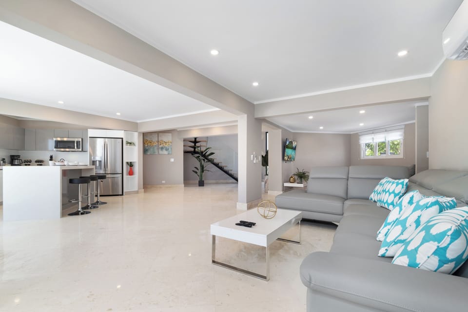 Spacious Living Area of the Villa in Noord Aruba  - Beautiful living room with an open layout, creating a sense of spaciousness - Open-concept living area seamlessly connected to a Kitchen - Well-chosen lighting fixtures adding functionality
